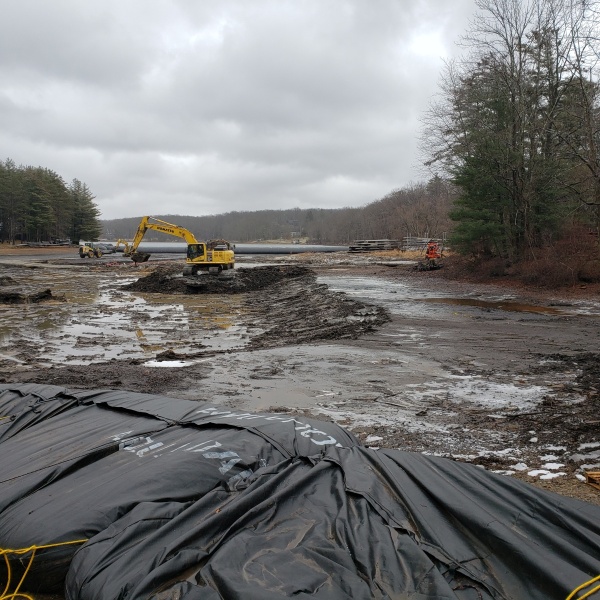 Backhoe removing sediment from cove floor