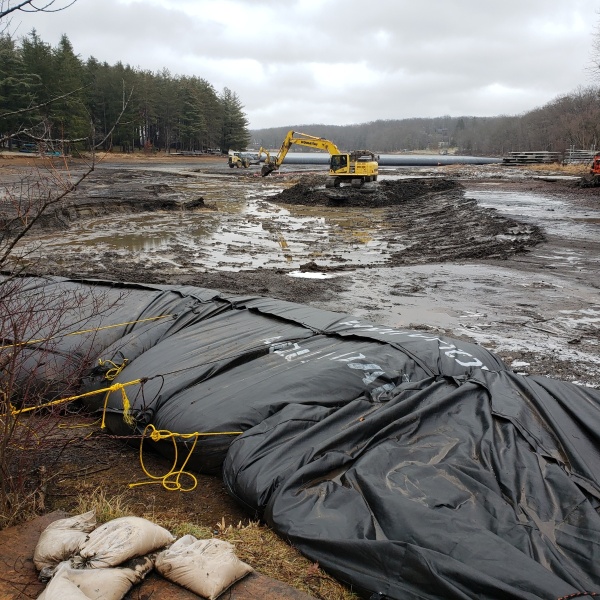 Backhoe removing sediment from cove floor